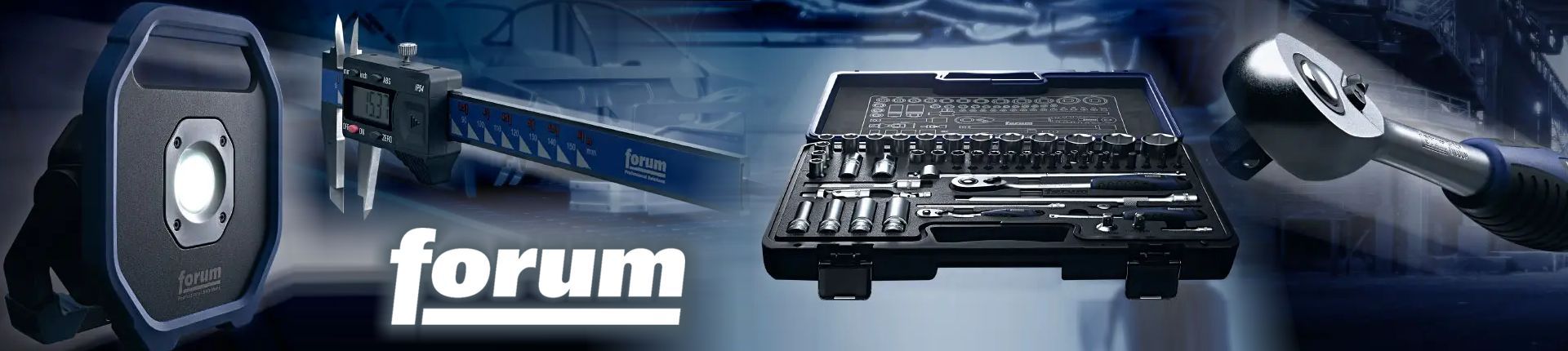 Bild Forum Leuchte, Messschieber, Koffer aufgeklappt mit diversem Werkzeugzubehör, Ratsche vor einem dunkelgrauen Hintergrund