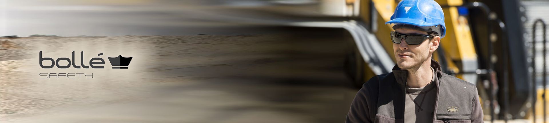 Bild Handwerker mit blauem Schutzhelm und einer schwarzen Sonnen-Schutzbrille von Bollé Safety