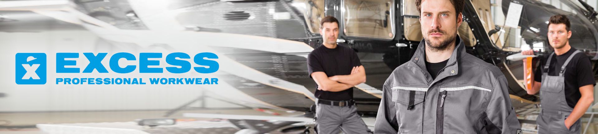 Bild Drei Männer in Excess Grey Arbeitskleidung vor einem in einem Hangar stehenden Hubschrauber