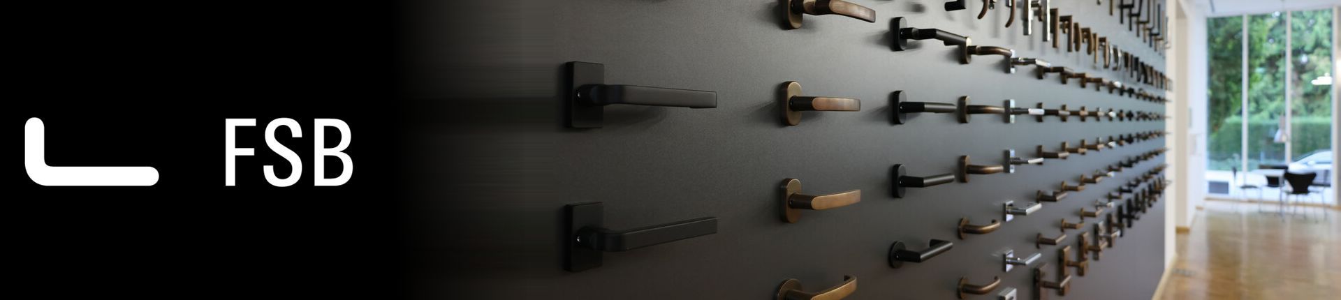Bild FSB Fenstergriffe, Türgriffe und Türknaufe Sortiment an einer dunkelgrauen Wand montiert