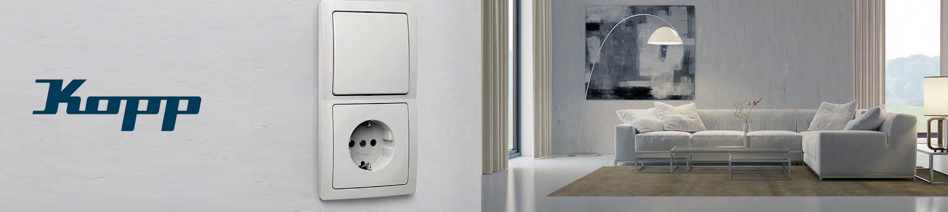 Bild Weiße Licht- und Steckdosen-Schalter-Kombination von Kopp montiert an einer grauen Wand mit Blick auf ein modern eingerichtetes Wohnzimmer