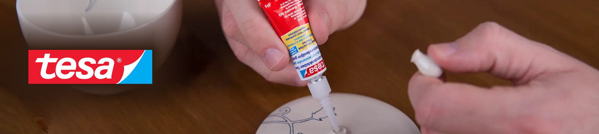 Bild Tesa Sekundenkleber-Gel-Tube im Einsatz beim Kleben einer weißen Porzellanschale
