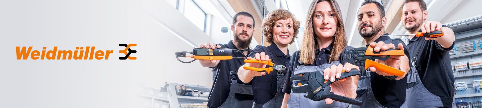 Bild Fünf junge Menschen in grauer Arbeitskleidung halten je ein Weidmüller Werkzeug in der Hand