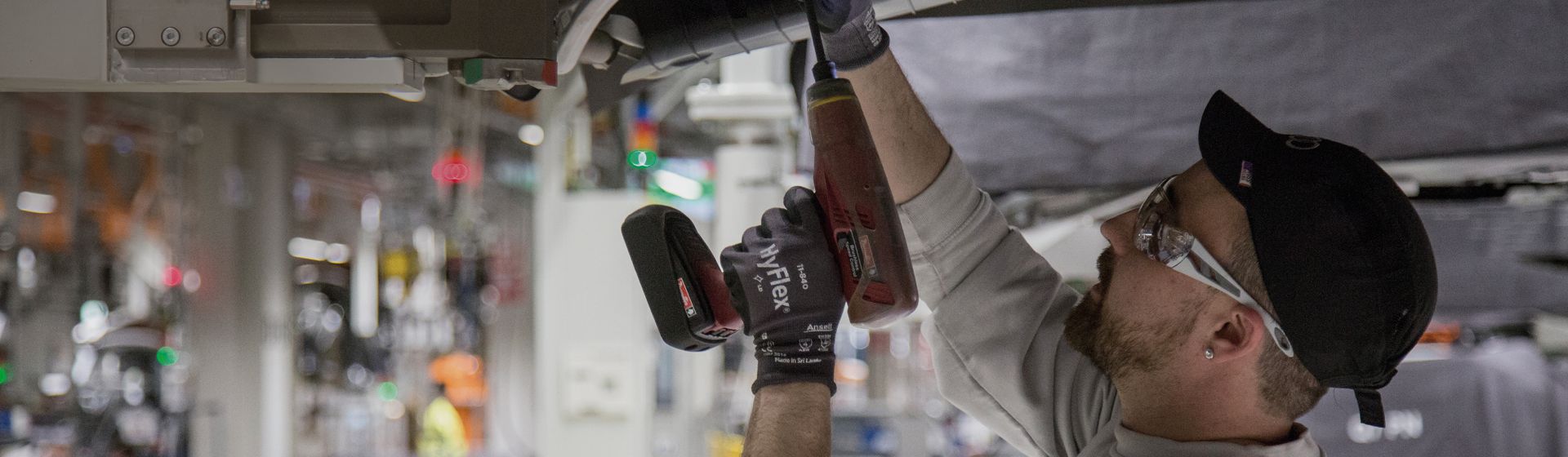 Handwerker mit Griphandschuhen von Ansell bei Arbeiten mit einem Akkuschrauber bild