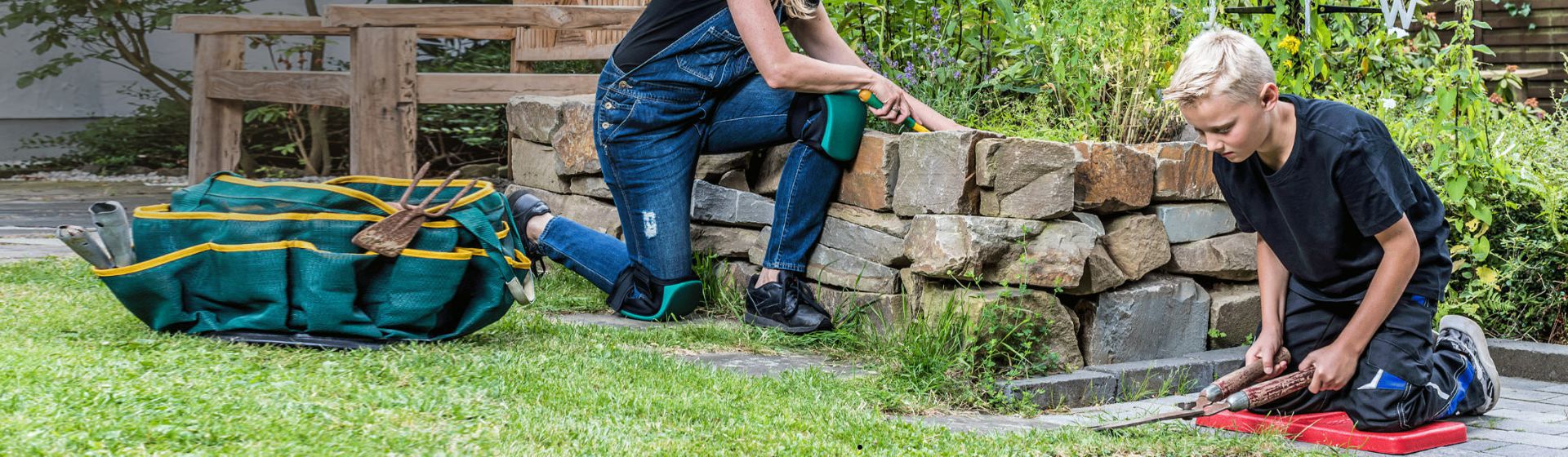 Frau und blonder Junge mit Knieschutz bei der Gartenarbeit bild