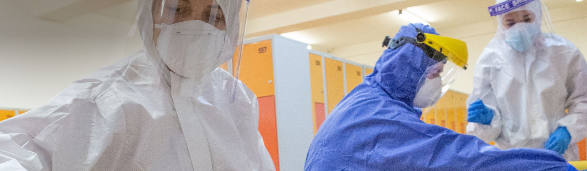 Arbeiterinnen in blauen und weißen Einweg-Schutzanzügen bild