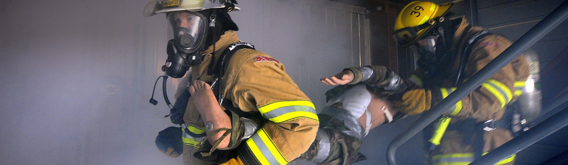 Zwei Feuerwehrmänner in voller Montur bei der Rettung einer Person bild