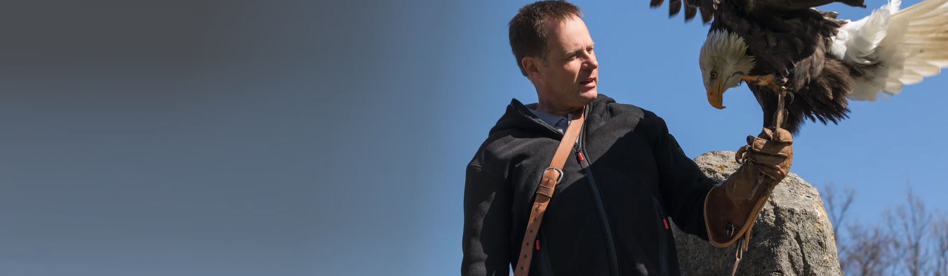 Mann in einer Winterjacke von Planam mit einem Adler auf der Hand bild