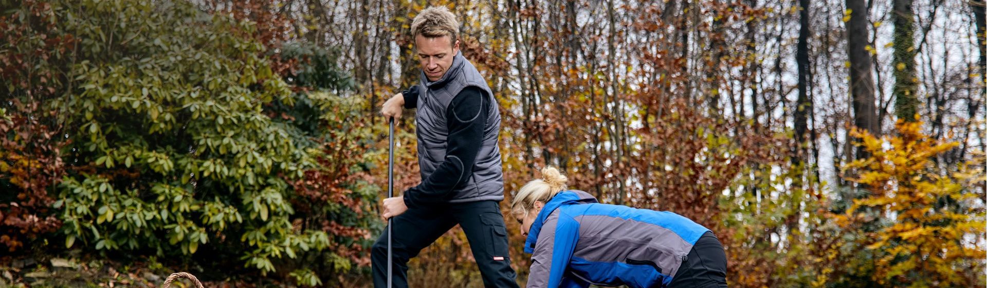 Mann in Arbeitskleidung mit grauer Winterweste bei der Gartenarbeit bild