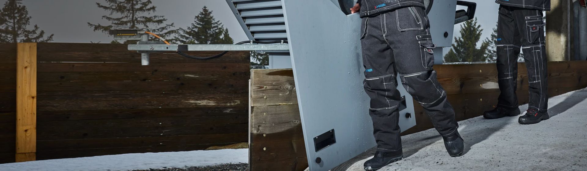 Zwei Männer in schwarzen Winter-Arbeitshosen von Planam bild