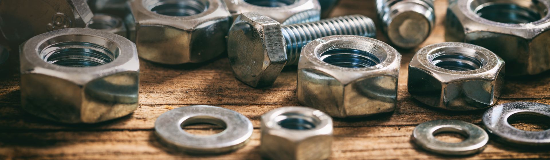 Schrauben und Muttern auf einem Holztisch liegend bild
