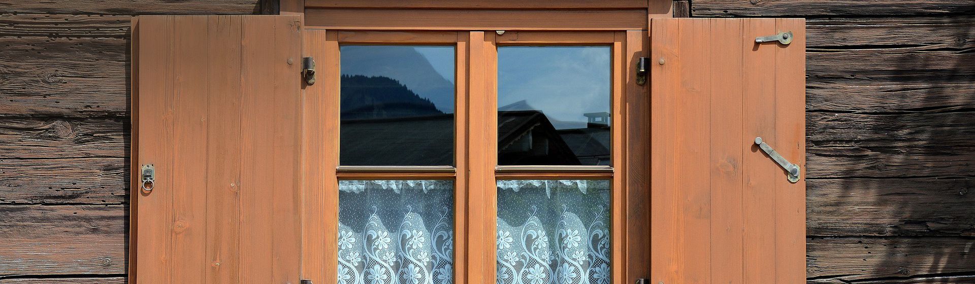 Fensterladen-Feststeller an einem braunen Fensterladen eines Bauernhauses bild