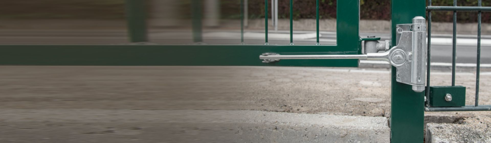 Silberfarbener Tür- und Torschließer von Alberts montiert an einem grünen Gartentor bild