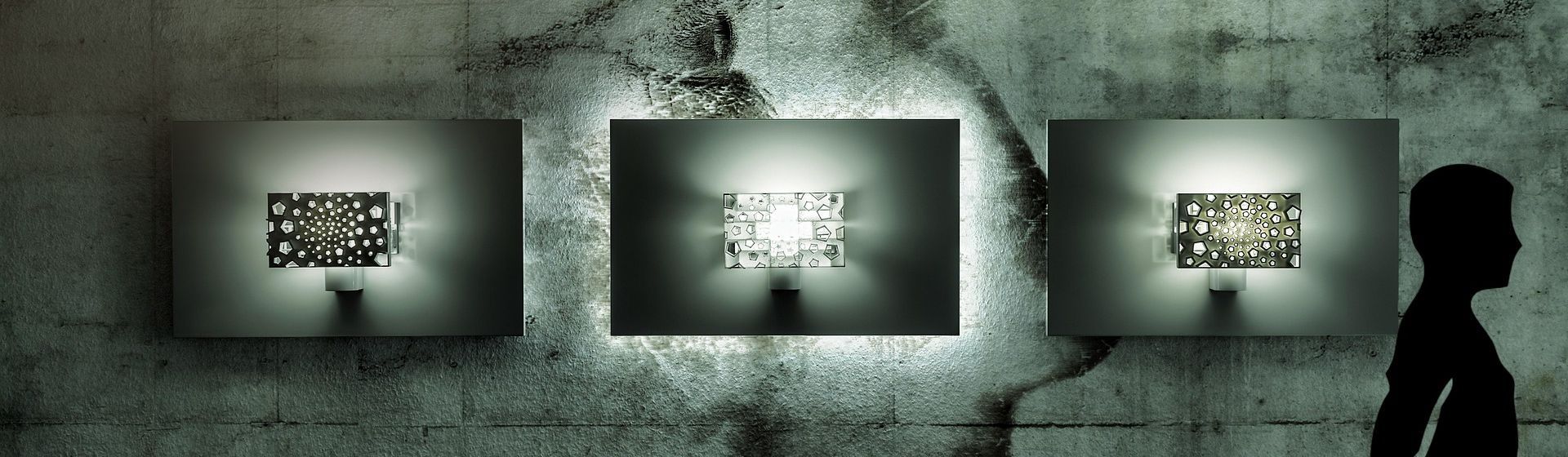 Drei silberfarbene Designer Wandleuchten an einer grauen Wand hängend bild