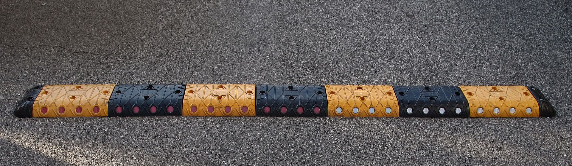 Schwarz-gelbe Fahrbahnschwelle auf einer geteerten Straße bild