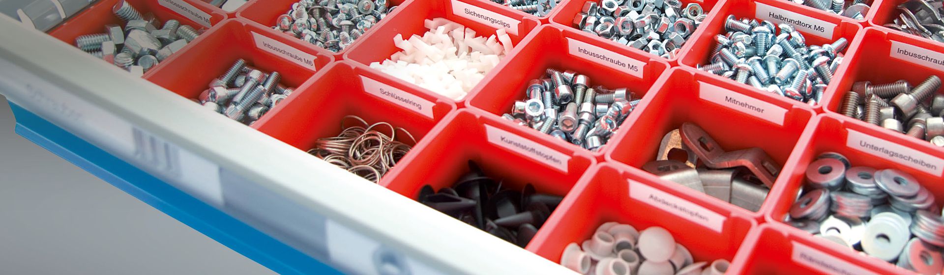 Rote Schubladeneinteilung gefüllt mit Kleinteilen wie Schrauben, Torx und ähnliche bild