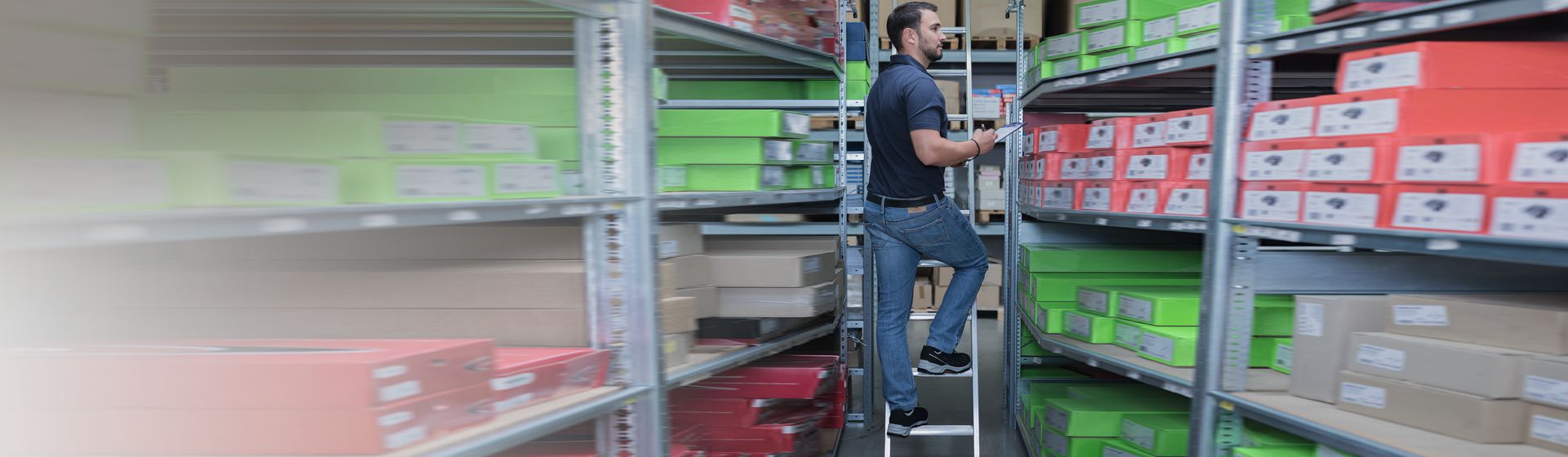 Mann auf einer Munk Regalleiter bei der Erfassung von Waren bild