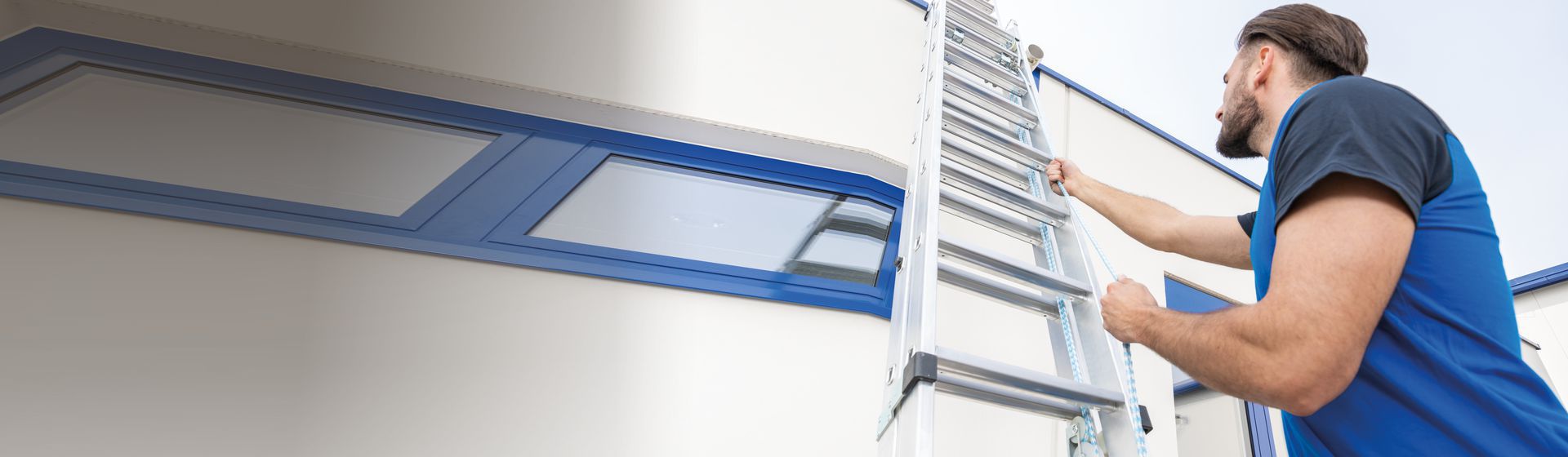 Handwerker bei der Bedienung einer Seilzugleiter bild