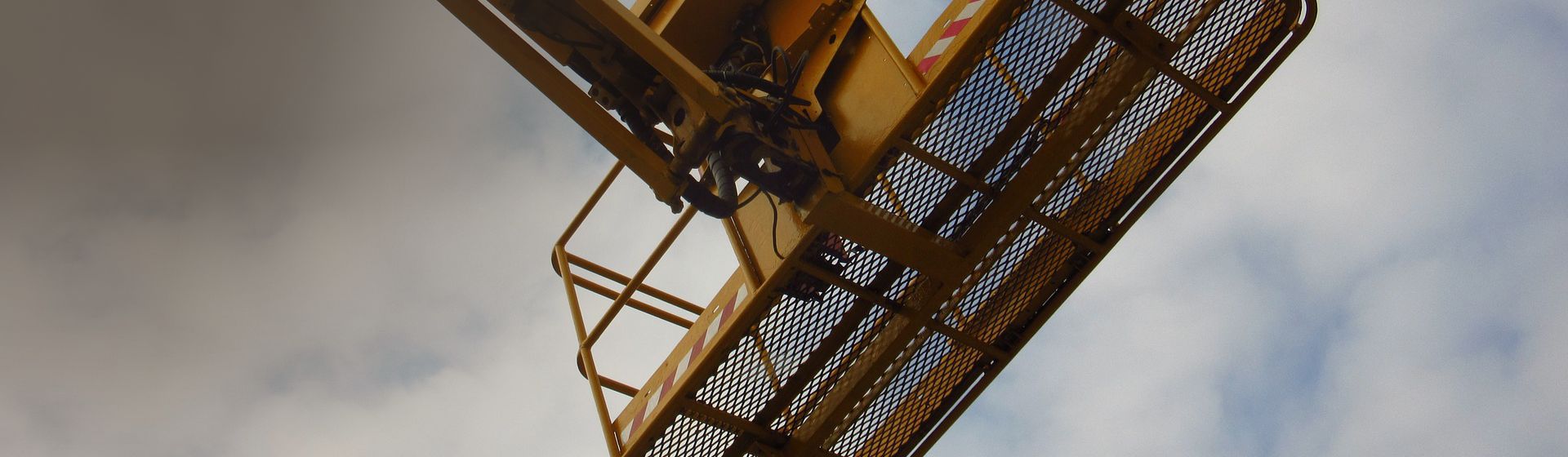 Orangefarbene Arbeitsbühne an einem Arm montiert bild