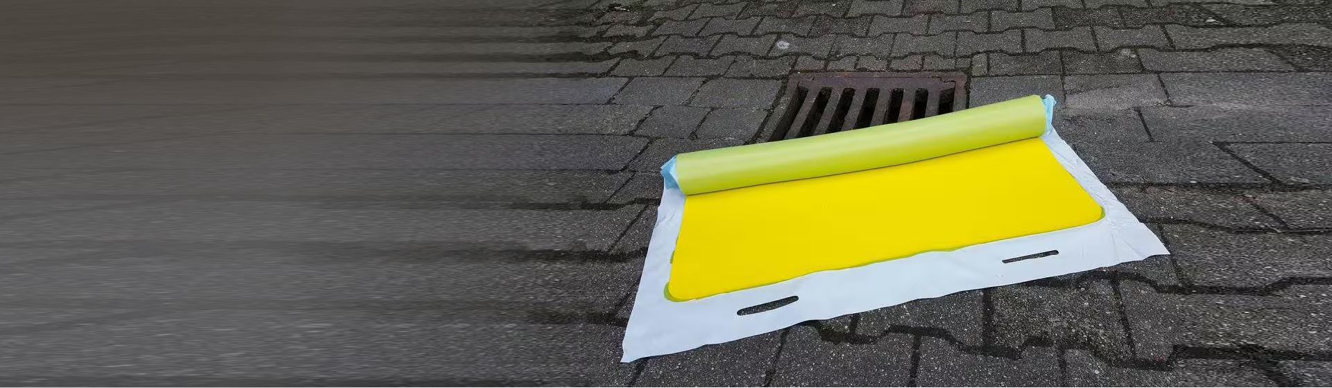 Gelbe Absperrmatte von Schoeller vor einem Gulli bild