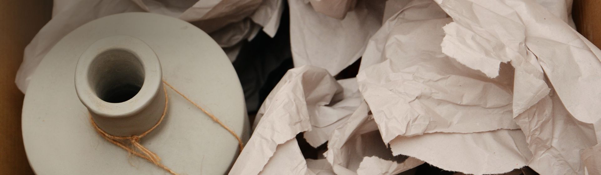 Packpapier in einem Karton um eine Vase herum verteilt bild