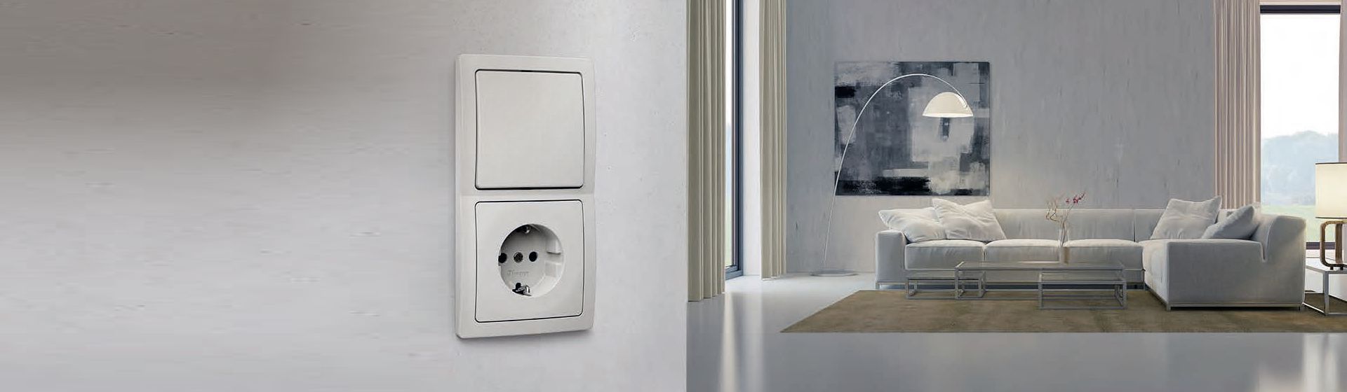 Weiße Kopp Lichtschalter-Steckdosen-Kombination montiert an einer grauen Wand mit Blick in ein hell eingerichtetes Wohnzimmer bild