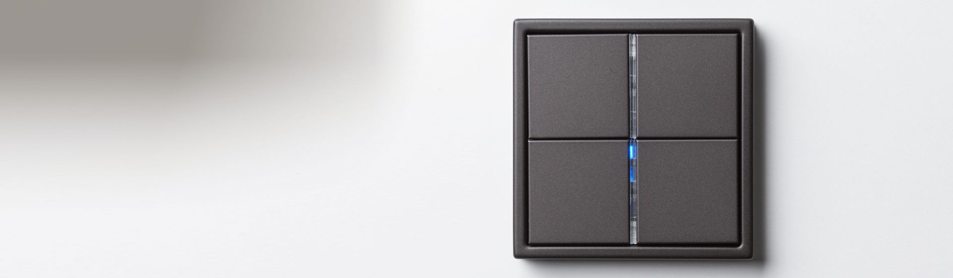 Schwarzer Tastschalter montiert an einer grauen Wand bild