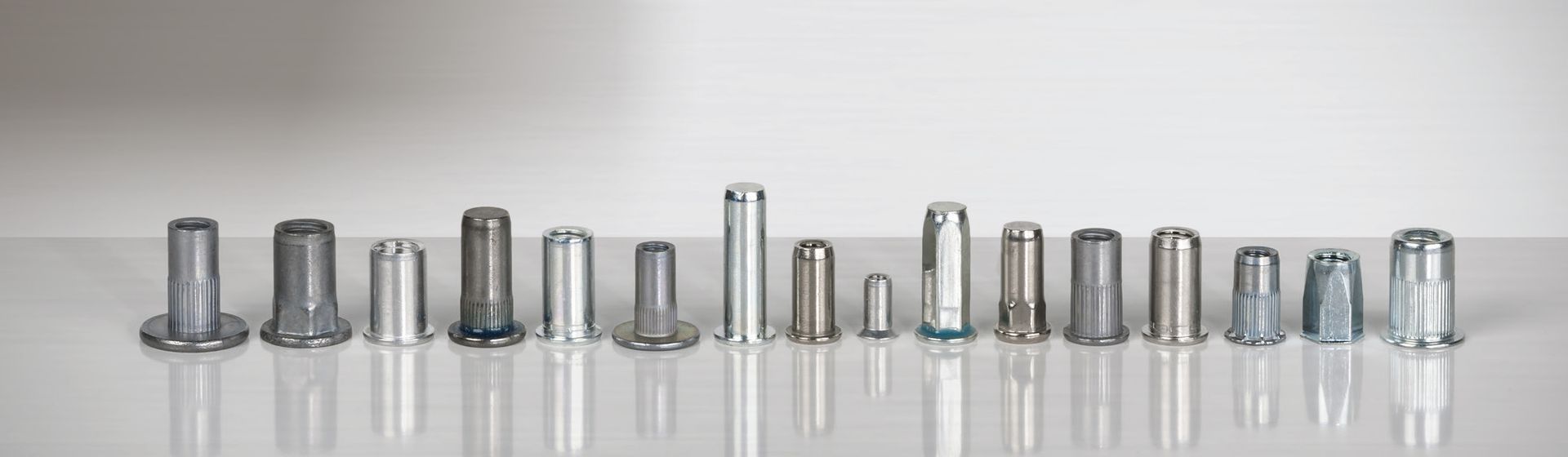 16 Gesipa Blindnietmuttern nebeneinander aufgereiht auf einer hellgrauen Fläche bild