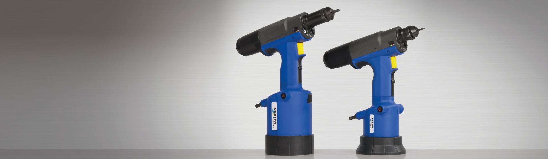 2 pneumatische Gesipa Blindnietgeräte nebeneinander stehend auf einer grauen Fläche bild