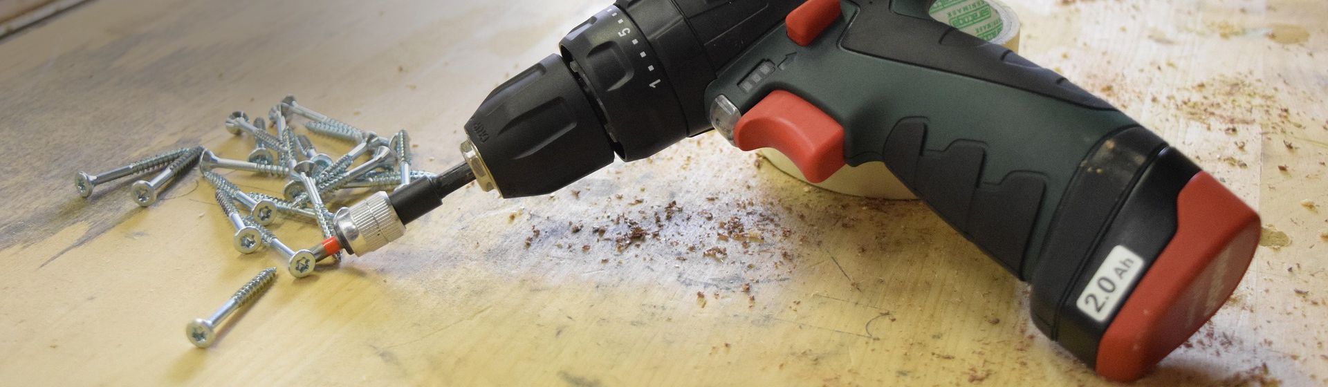 Metabo Bohrmaschine auf einer Werkbank neben Schrauben liegend bild