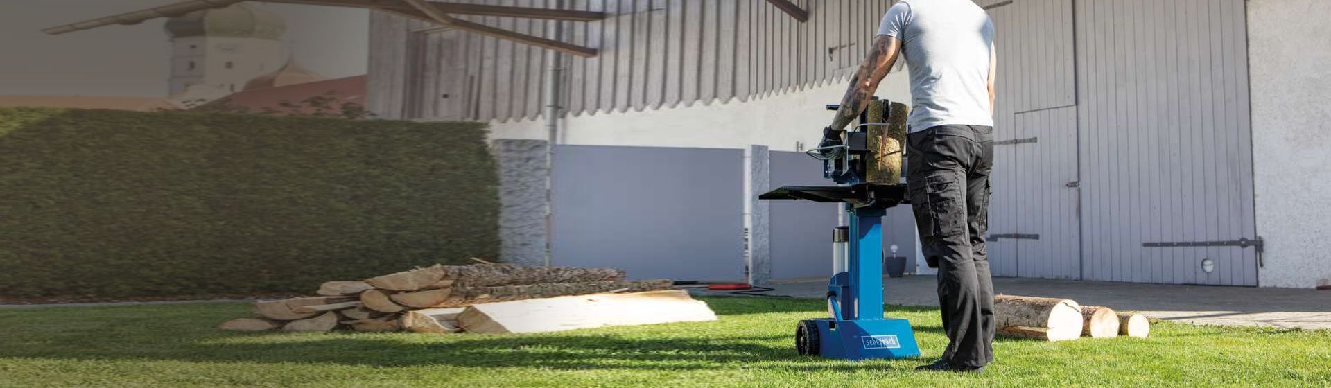 Mann spaltet Brennholz in einem Garten mit einem Scheppach Holzspalter bild