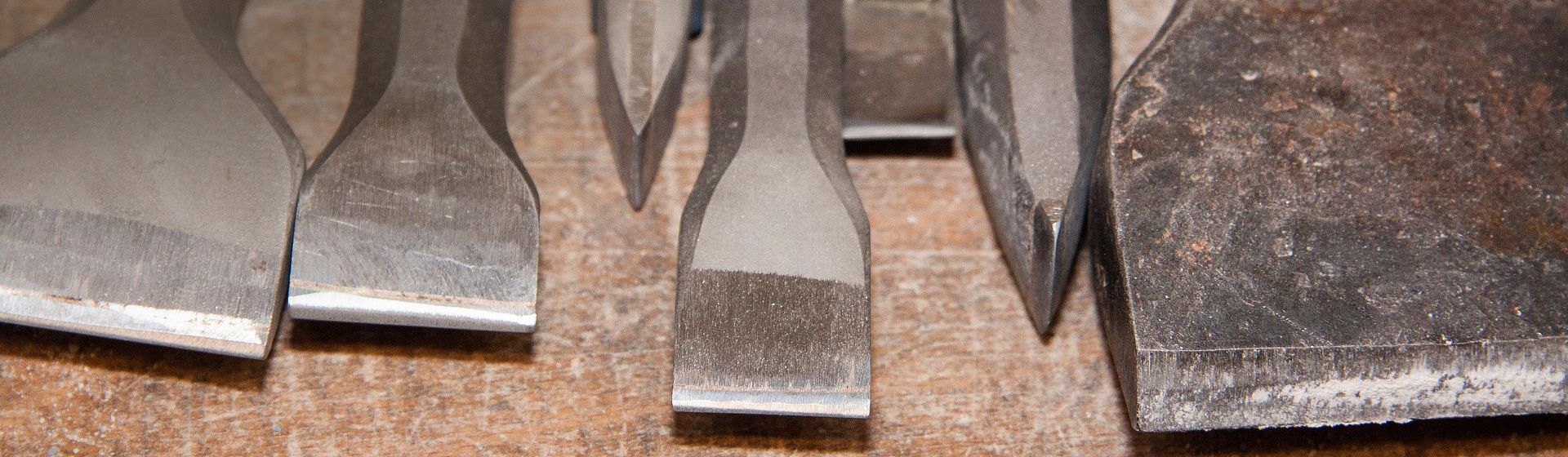 Die Spitzen von sieben nebeneinander liegenden Meißeln bild