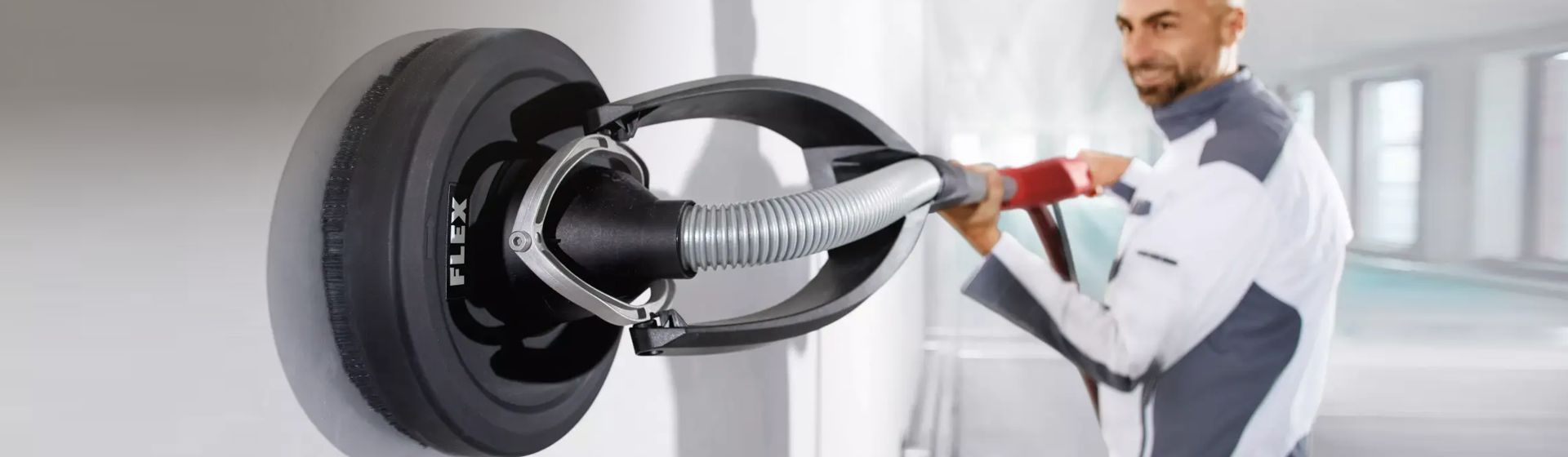 Handwerker beim Bearbeiten einer weißen Wand mit einer Flex Sanierungsgiraffe bild