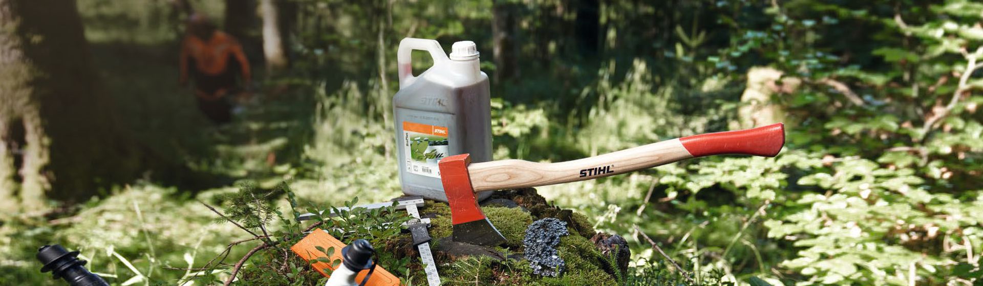 Stihl Axt in einem bemoosten Baumstumpf steckend im Wald bild