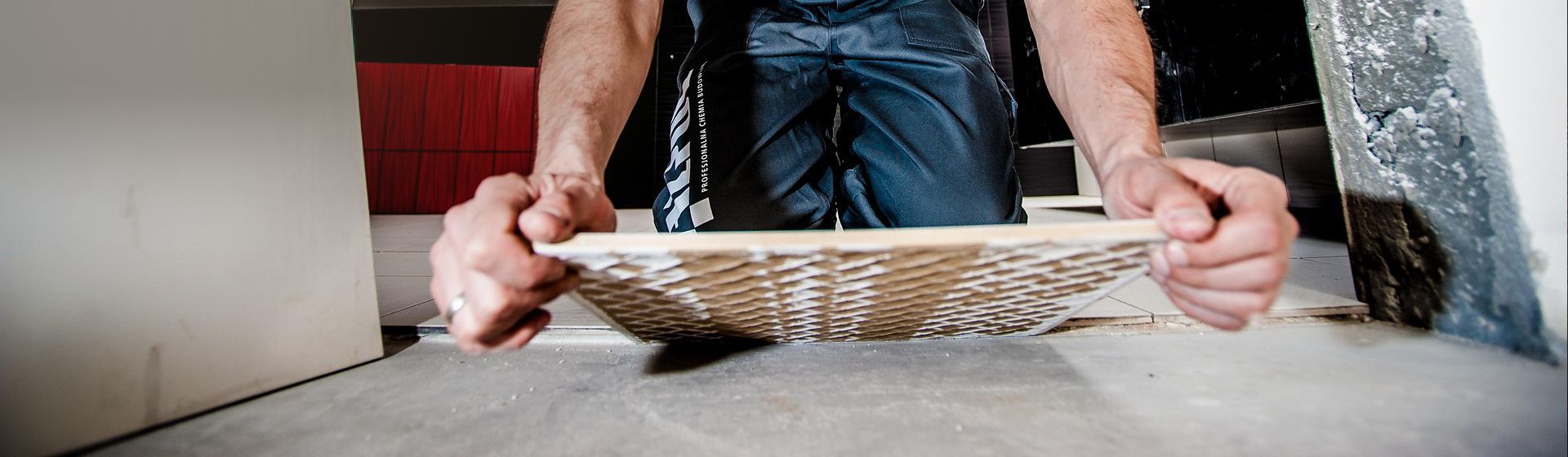 Handwerker verlegt eine Bodenfliese bild