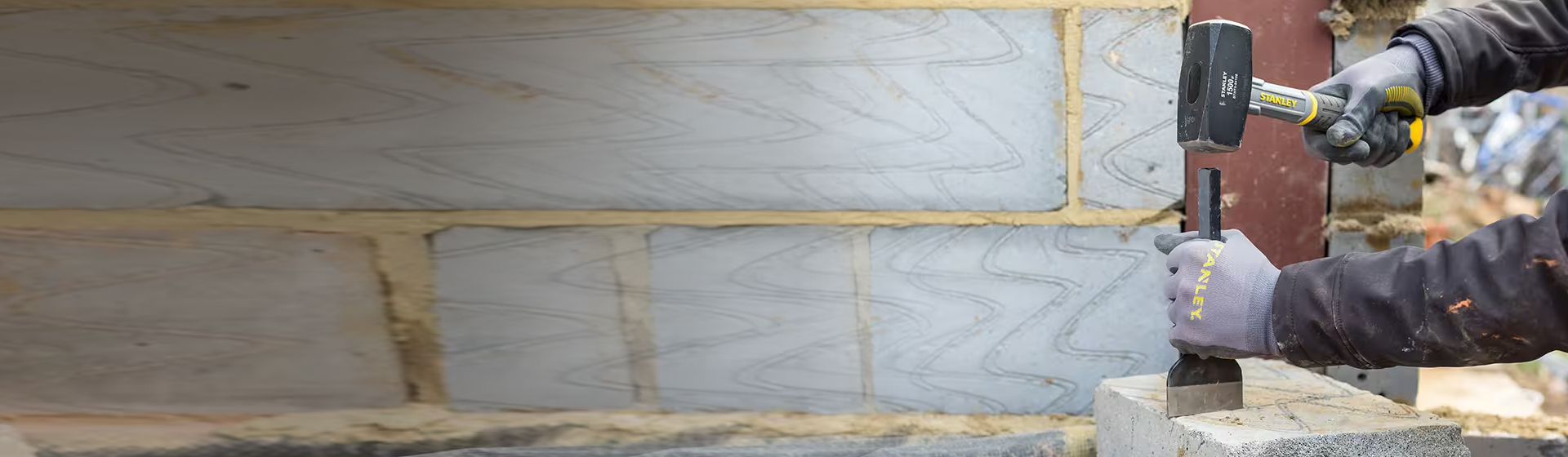 Handwerker bearbeitet einen Stein mit Hilfe eines Meißels und eines Fäustels bild