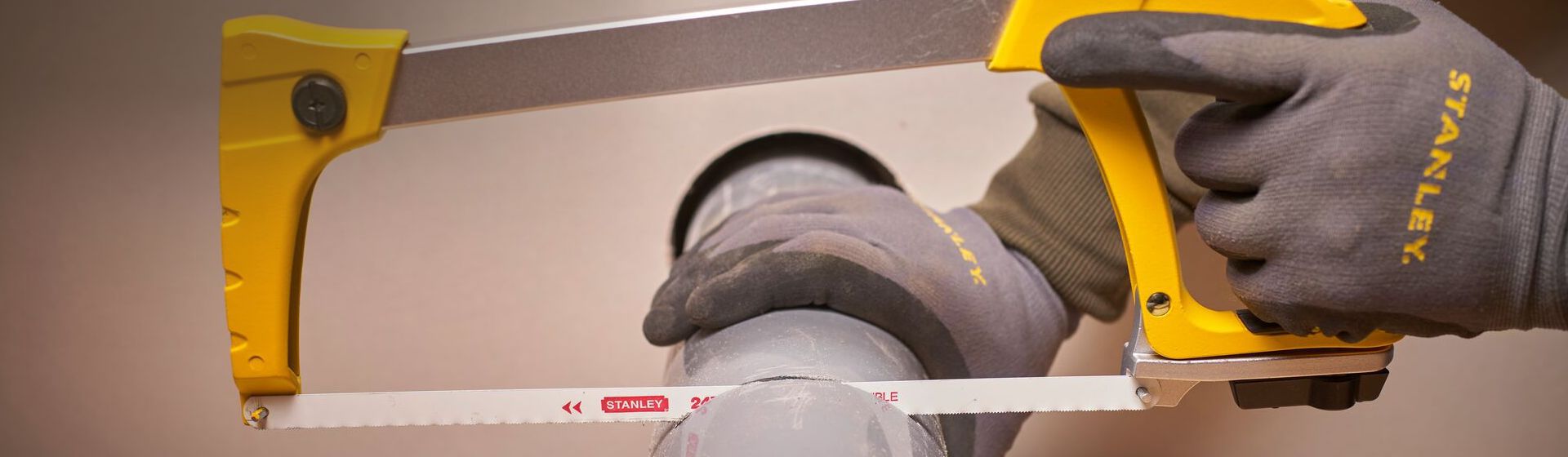 Bügelsäge von Stanley beim Sägen eines Rohrs bild