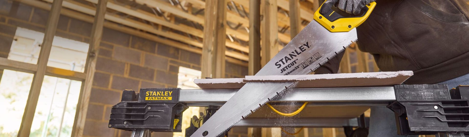 Mann sägt mit einer Dämmstoffsäge von Stanley eine Dämmstoffplatte bild