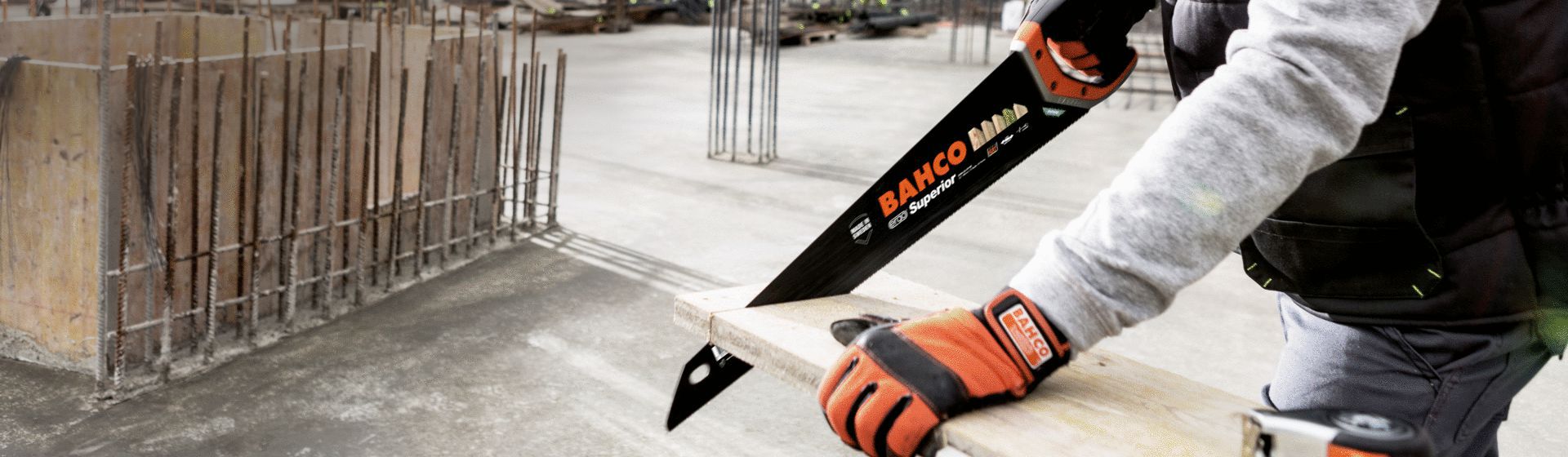 Mann durchtrennt ein Holzbrett mit einem Fuchsschwanz von Bahco bild