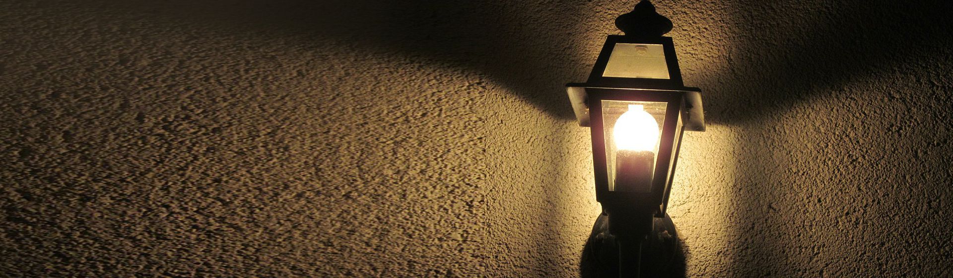 Schwarze Außenleuchte in Laternendesign montiert an einer Hauswand bild