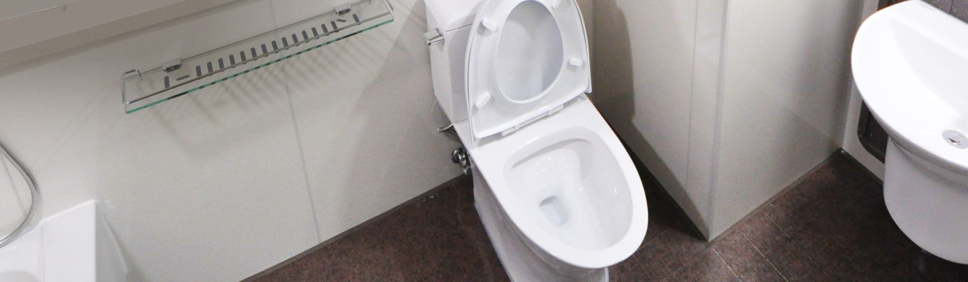 Weiße Toilette mit offnem Deckel in einem Badezimmer bild