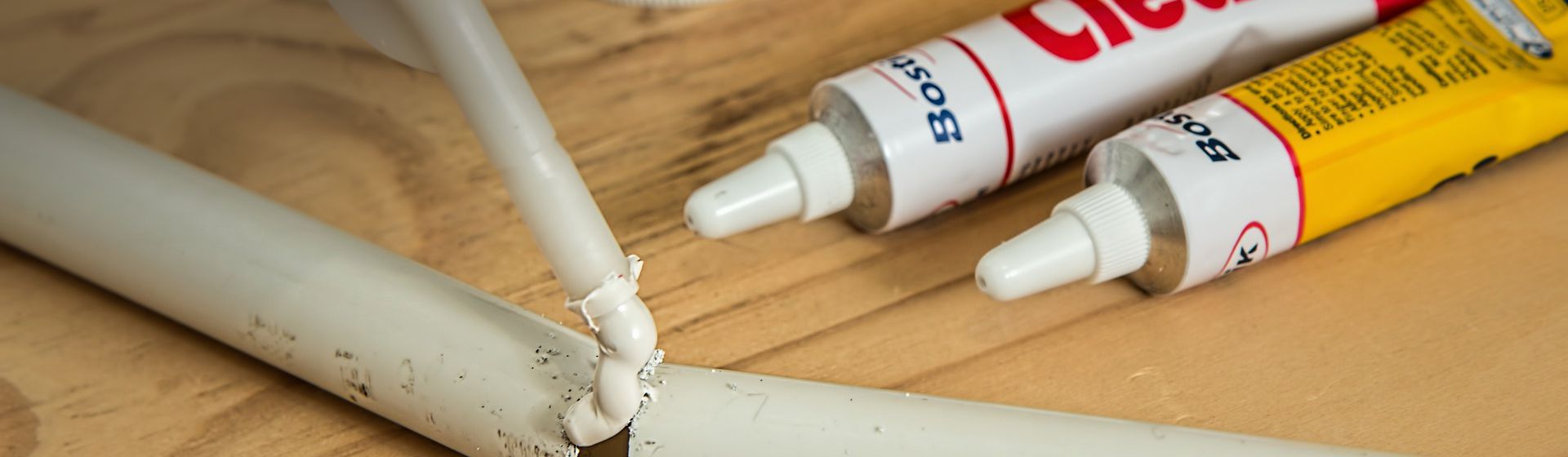 Weißes Rohr wird mit einer weißen Dichtmasse verschlossen bild