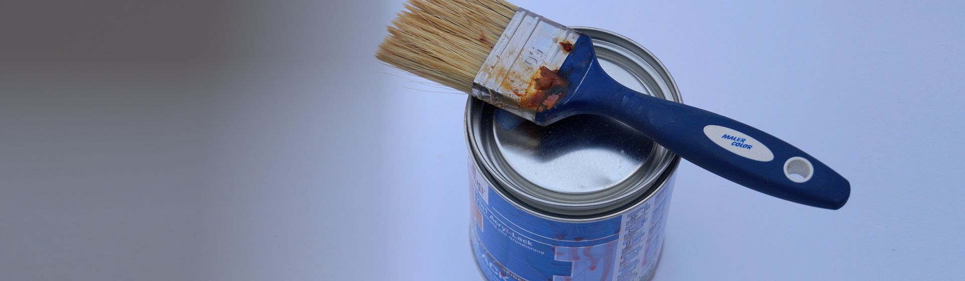 Farbdose & Pinsel vor blauem Hintergrund bild