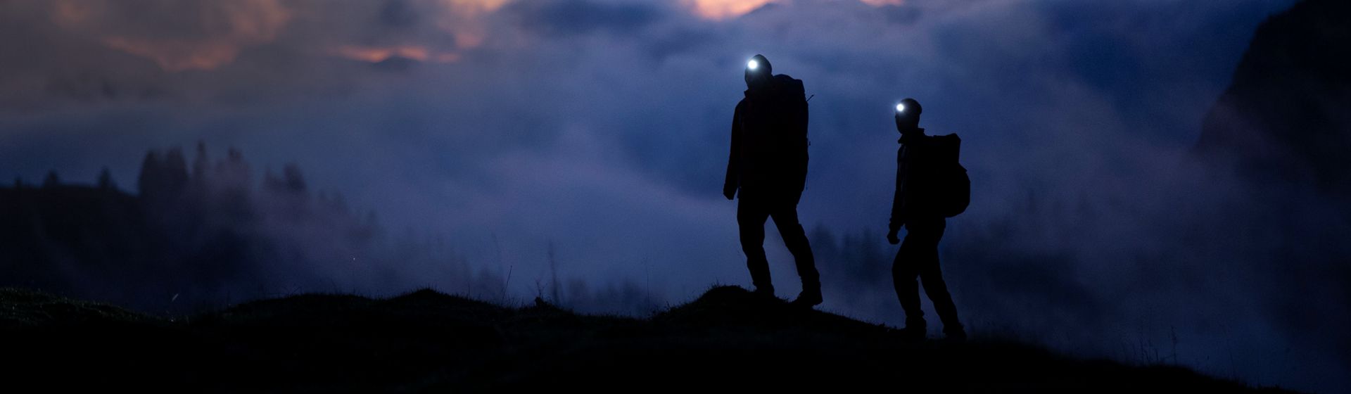 Personen mit Ledlenser Stirnleuchten bei Nacht in den Bergen bild