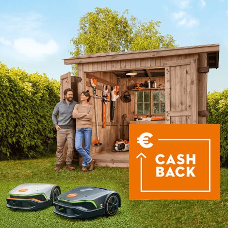 Ein Mann und eine Frau stehen vor einem Gartenhaus aus Holz mit geöffneten Türen, in welchem diverse Stihl Gartengeräte aufbewahrt werden, im Vordergrund zwei iMow Mähroboter.